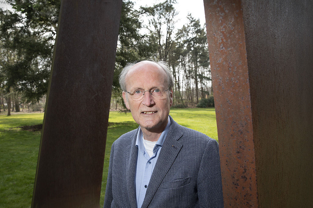 Hans Siebers photographed outdoors between two weathered steel plates
