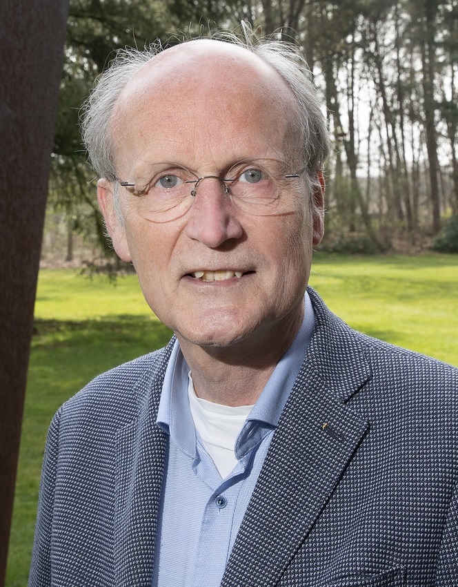 Portrait of Hans Siebers outdoors beside a steel sculpture