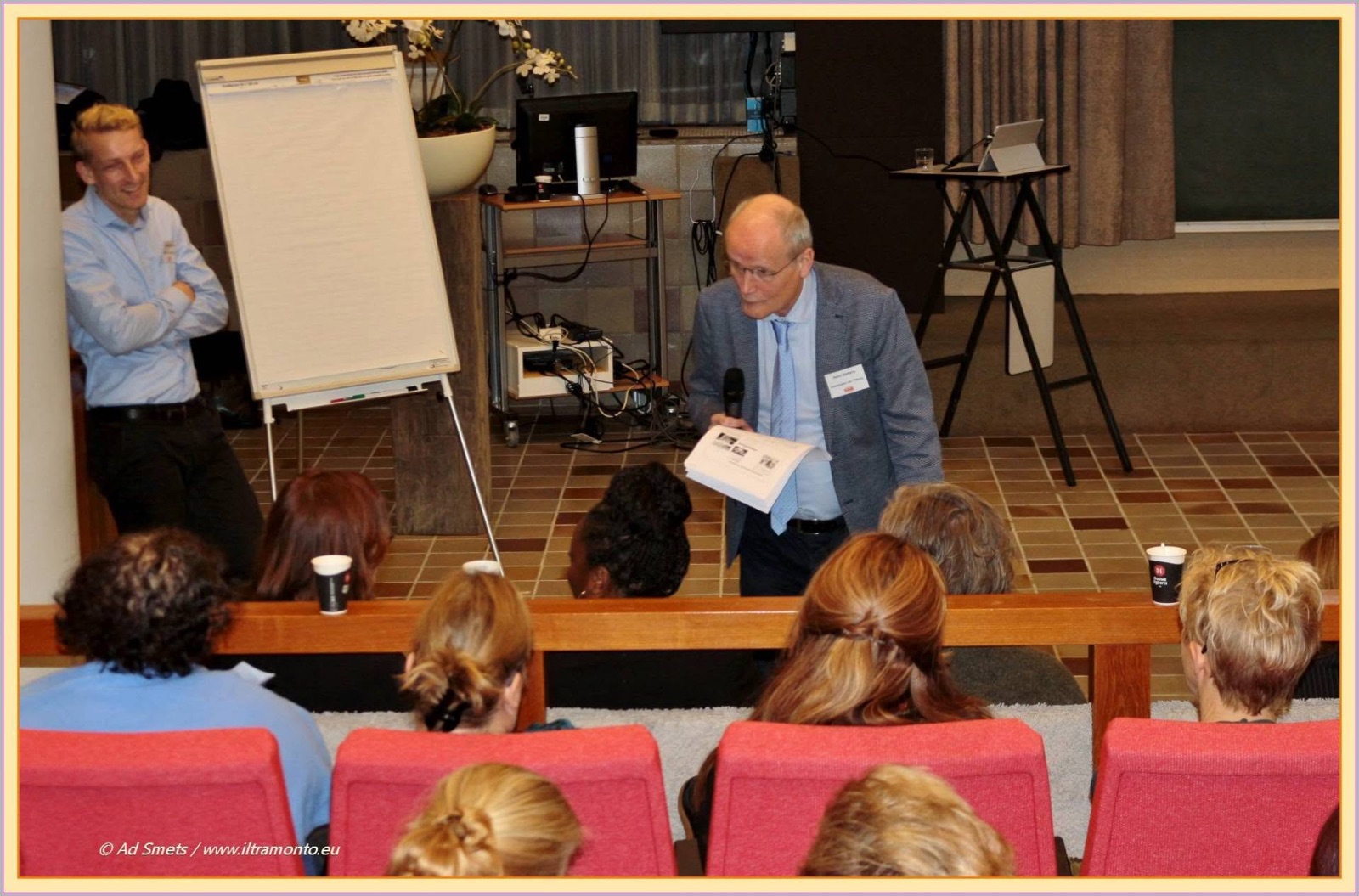 Hans Siebers speaking with a microphone to a seated audience